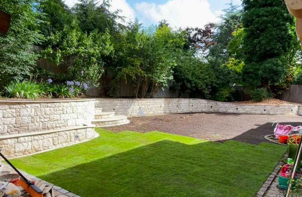 Landscaped garden with stone retaining walls and lawn